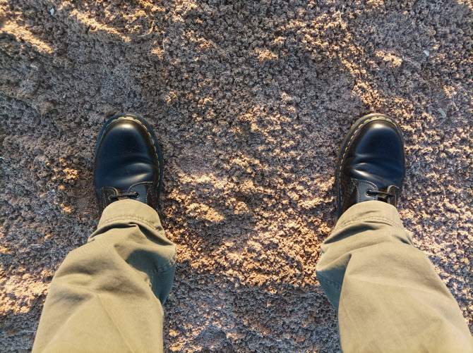 мои ноги в ботах Dr.Martens на пустынной почве, усеянной крупицами морской соли