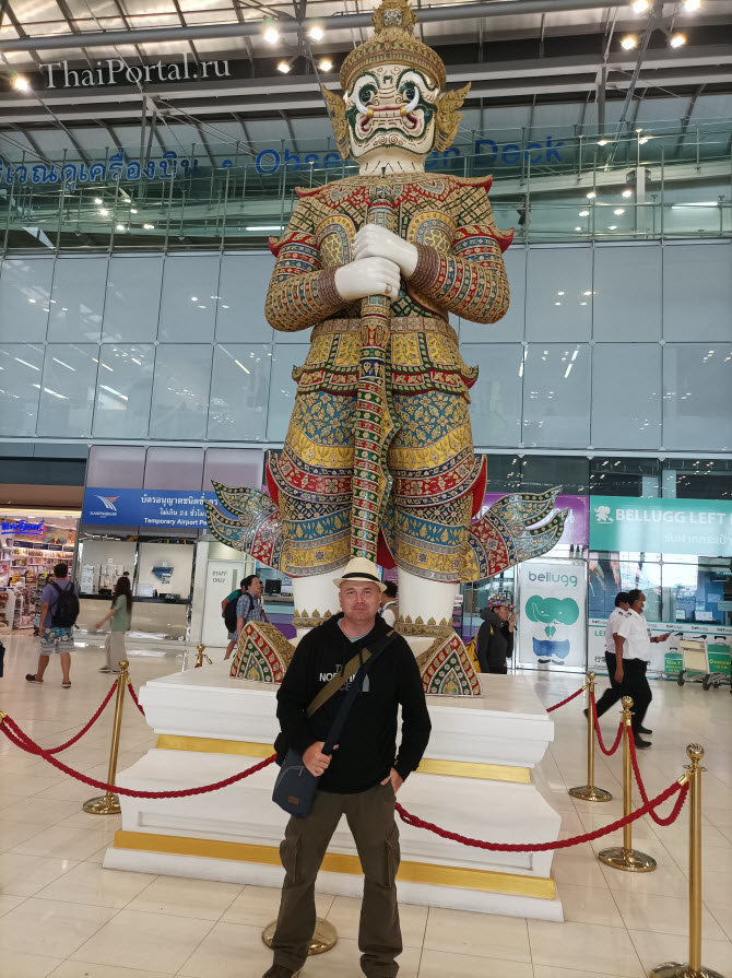 на фото я и демон якша в виде огромной статуи на заднем фоне в аэропорту Суварнабхуми столицы Таиланда